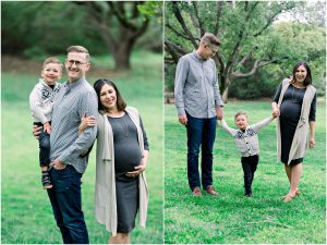 A smiling family with a pregnant mom, dad, and young son poses for a maternity session in a green, tree-filled park.