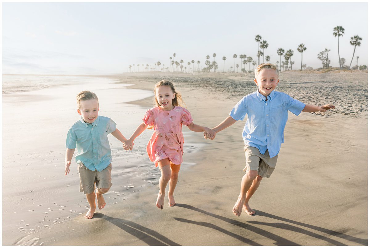 Candid photo of kids running on the beach, Extended family portraits on family vacation in Oceanside California