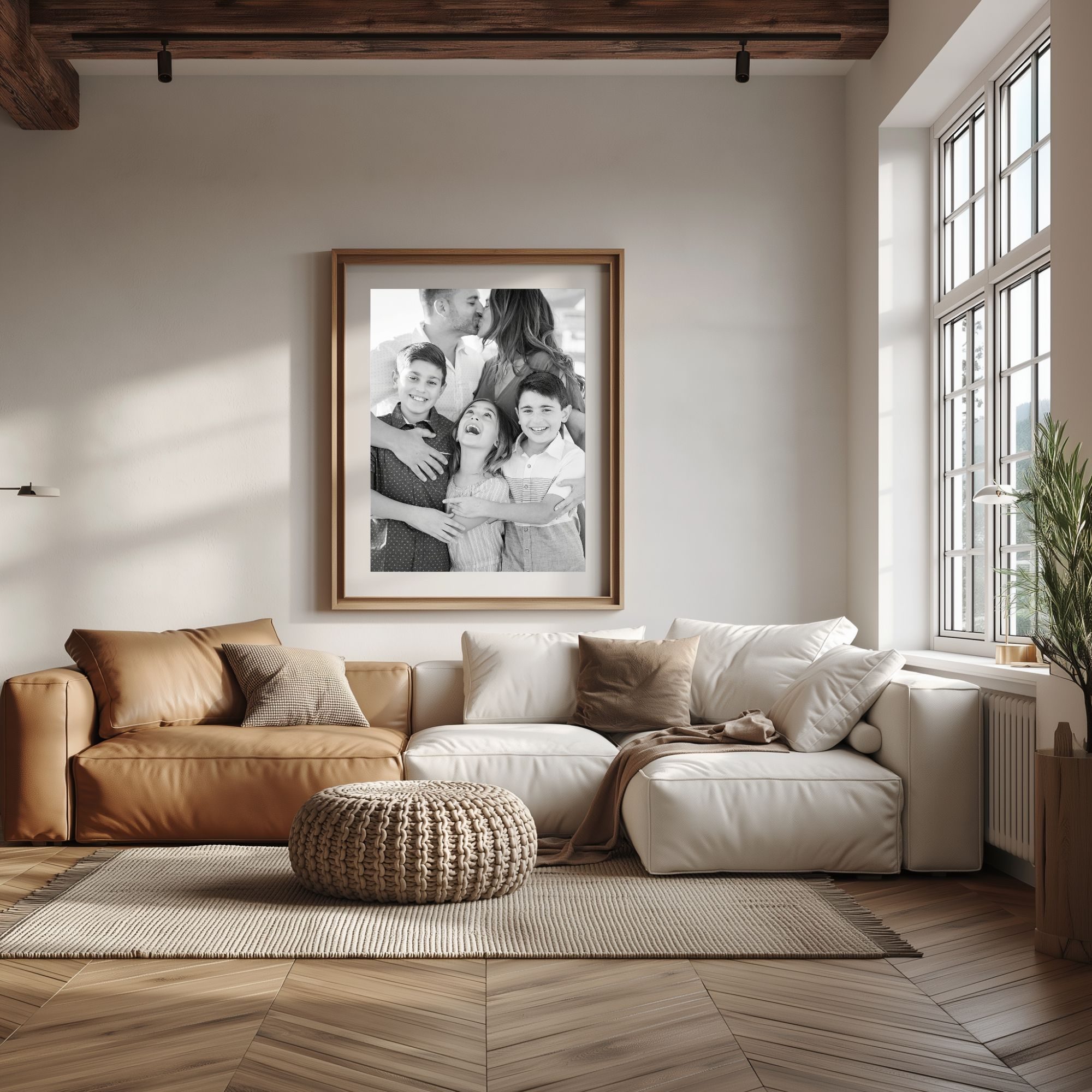 Framed family portrait above a leather sofa in a sunlit living room