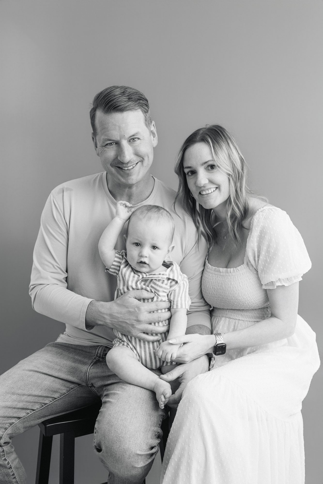 Black and white studio portrait of parents with their baby son