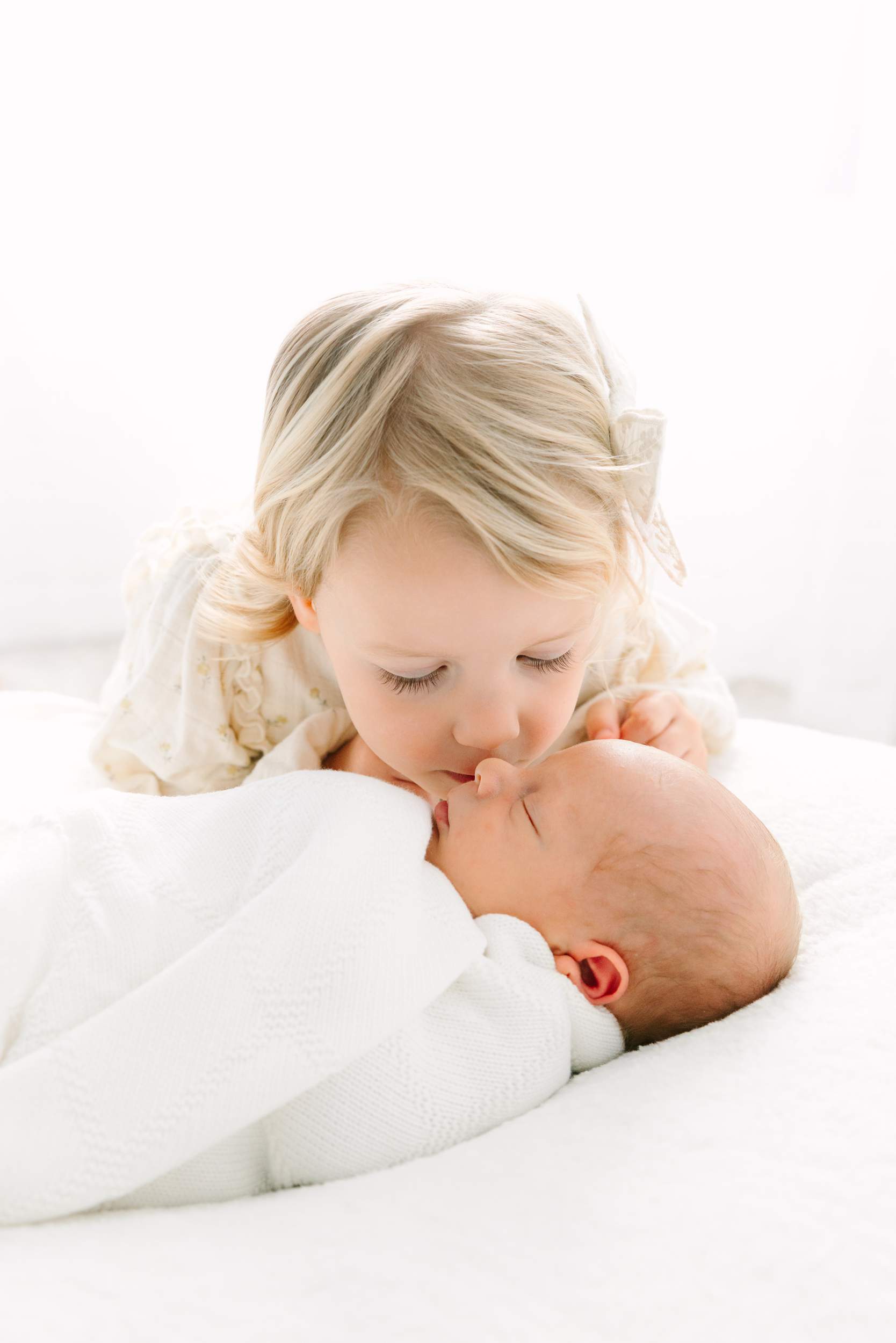 A girl kissing a baby.