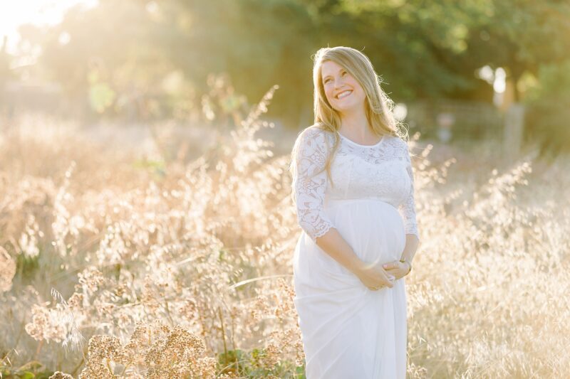 Maternity photo shoot of a pregnant mom laughing